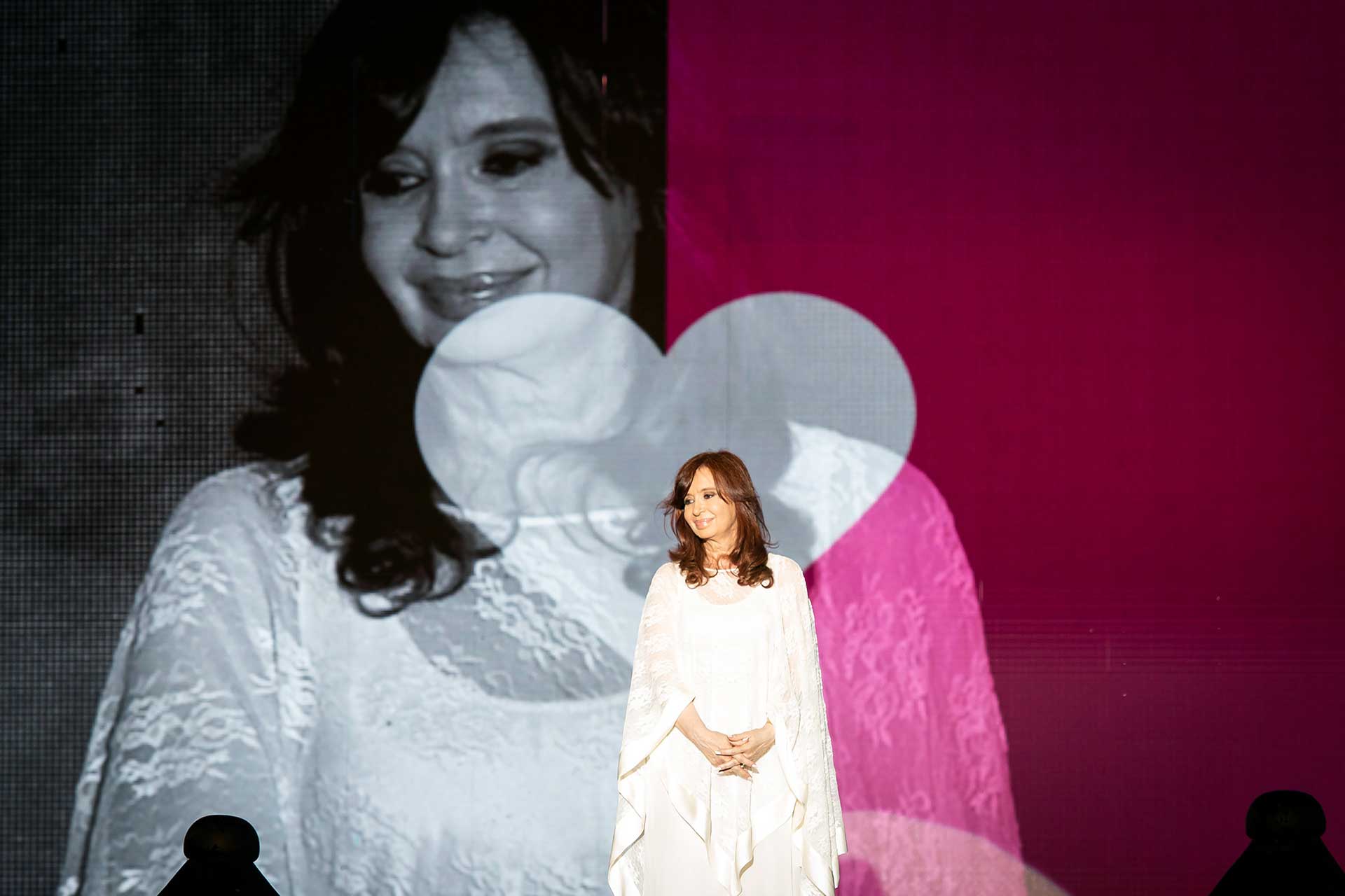 Fotografía de Cristina Fernández de Kirchner, Vicepresidenta de la Nación. De fondo, una pantalla que capta el momento acompañándolo con un corazón